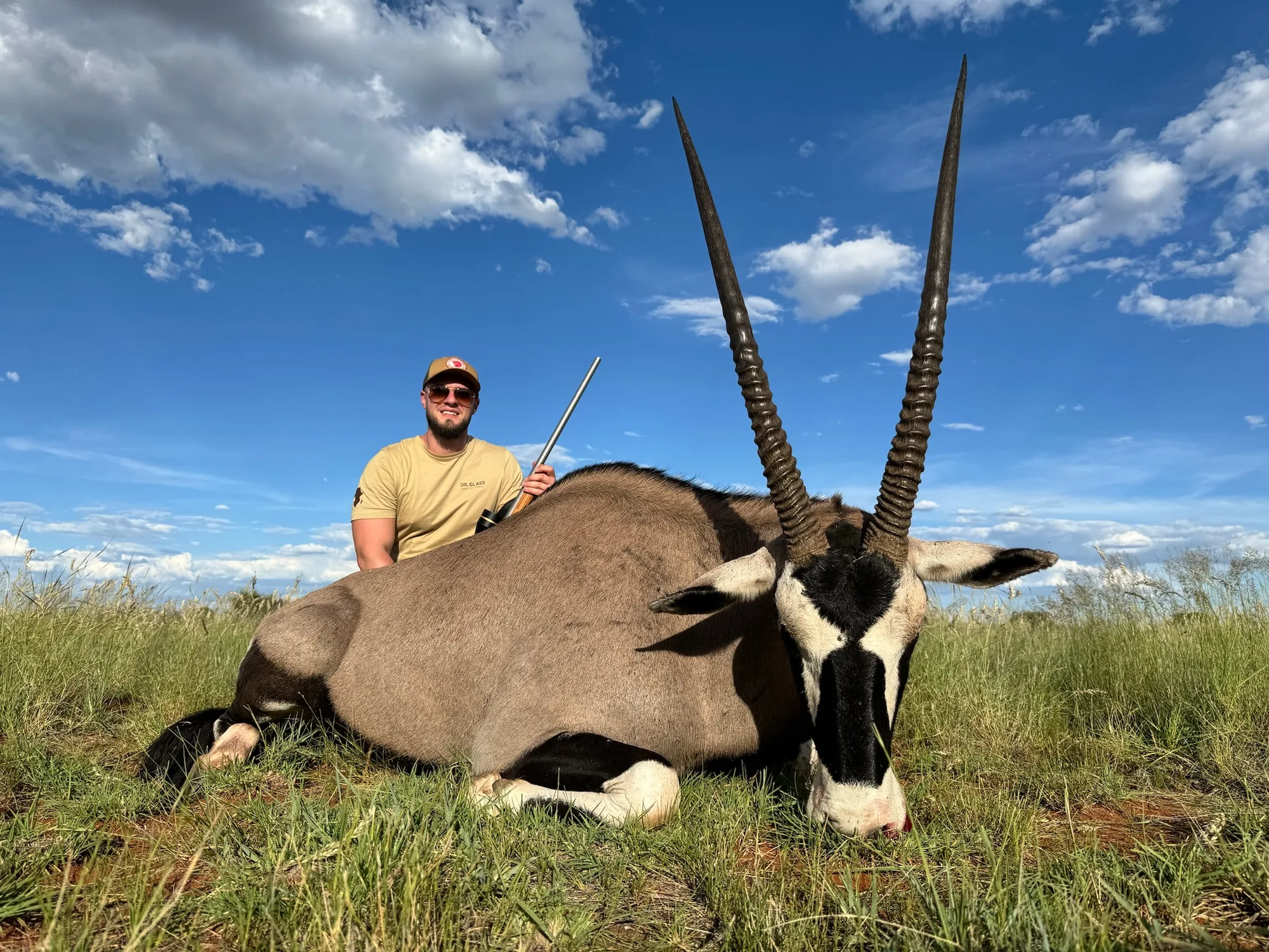 A hunter with a gemsbok taken on the open Kalahari plains
