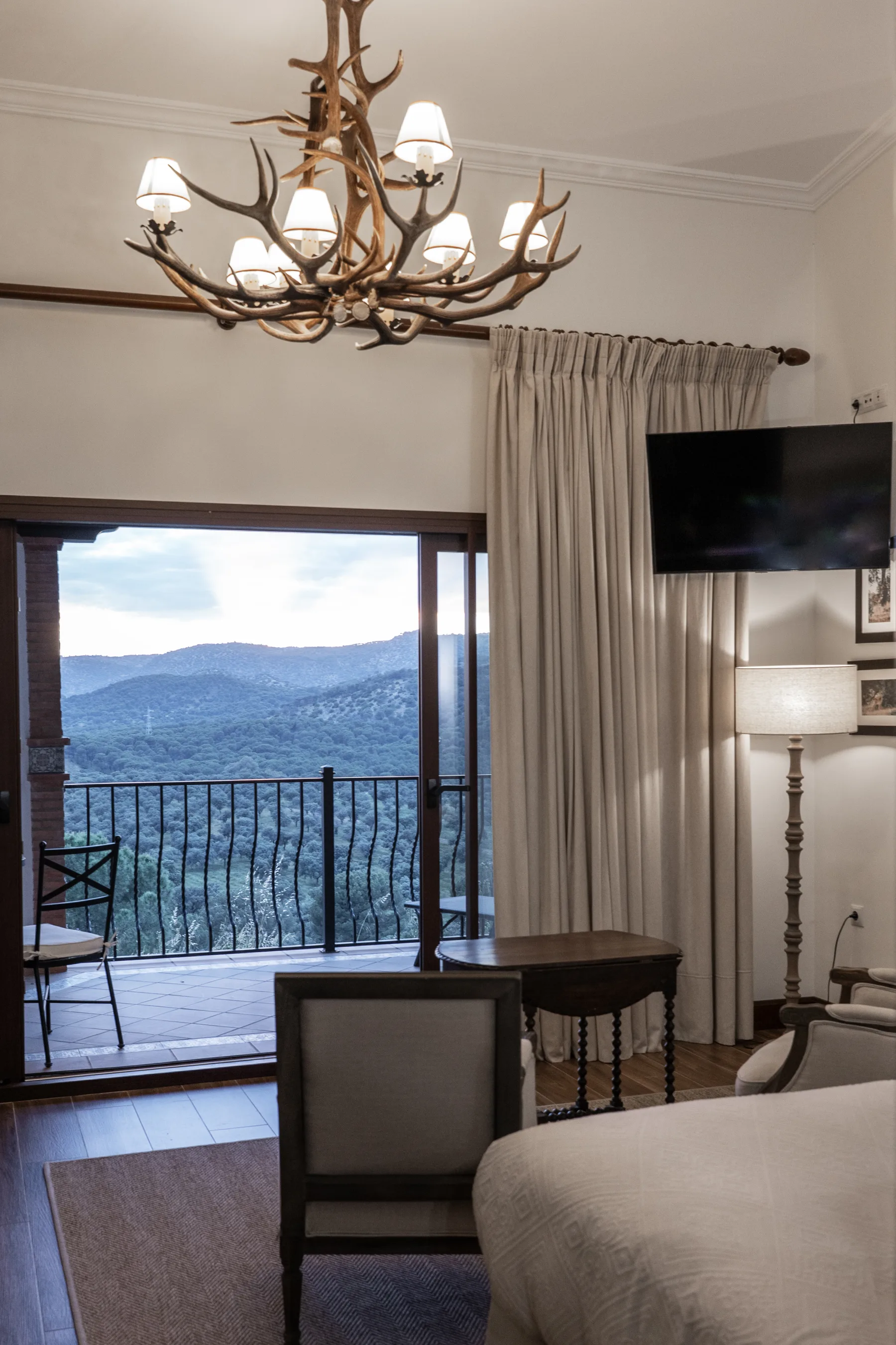 A bedroom's balcony door open to the sierra, the valley framed in the doorway