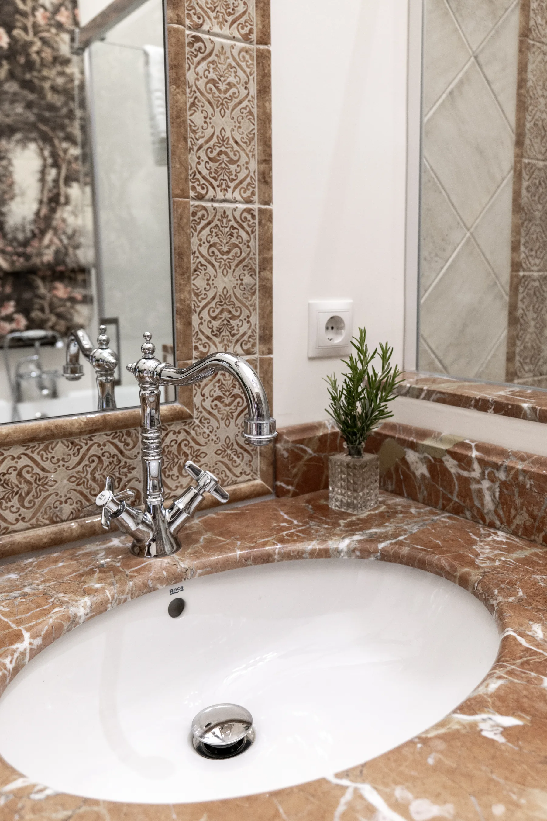 A rose-marble basin with polished period taps