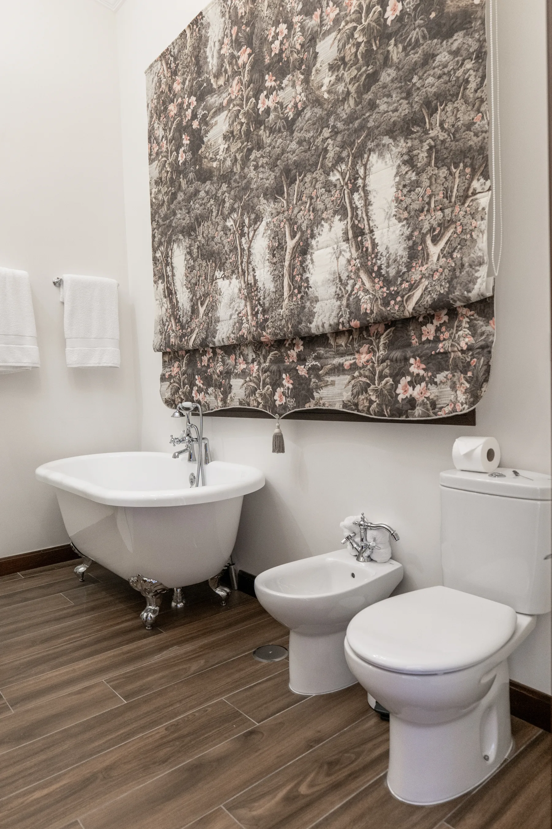 The clawfoot tub beneath a toile blind