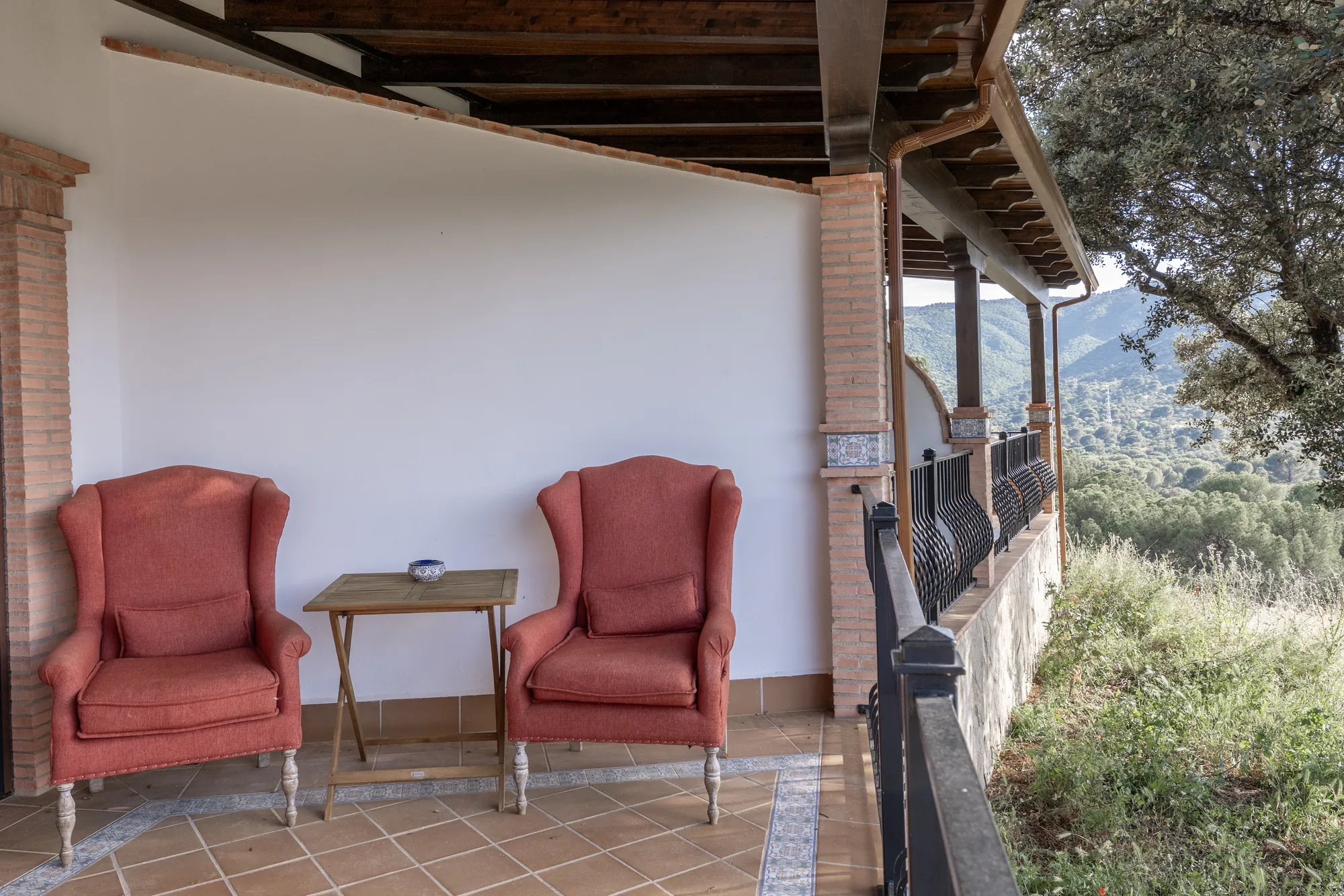 Two wingback chairs on the porch, the valley beyond the balustrade