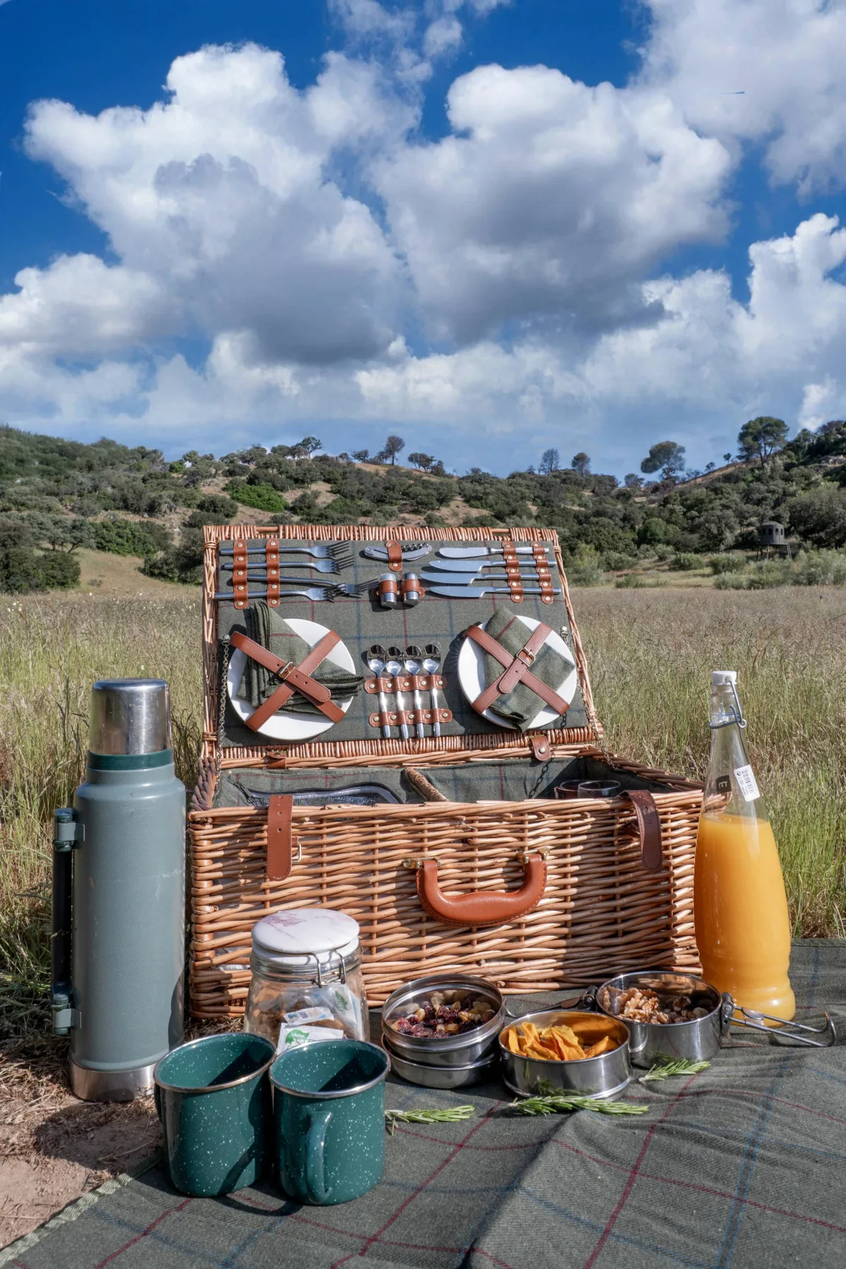 An open picnic hamper laid out in the meadow